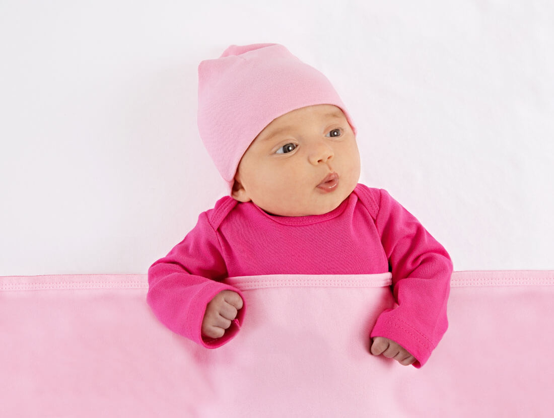 Baby wearing pink with a pink blanket