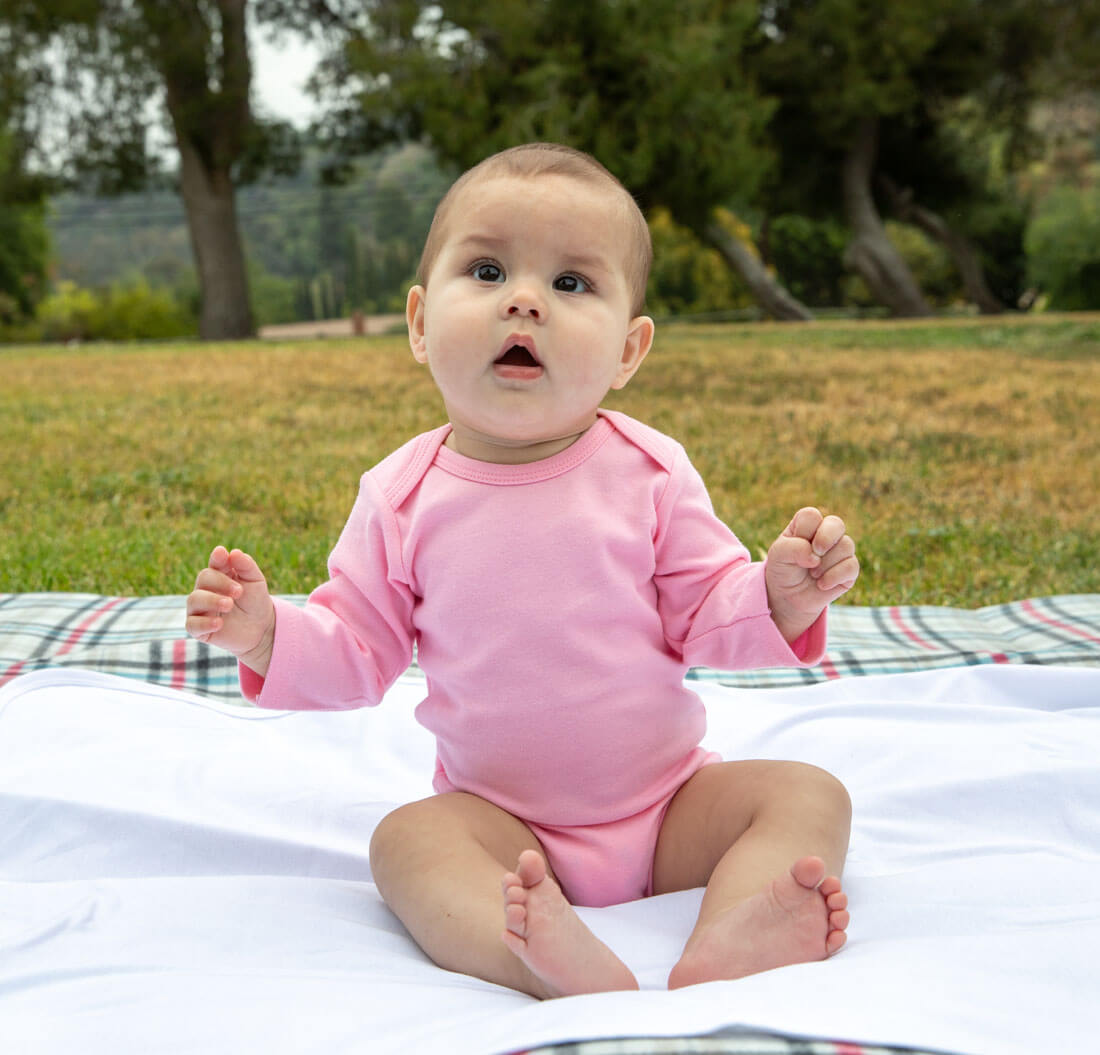 baby wearing pink long sleeve onesie